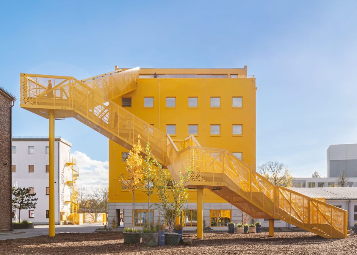 Gelbe skulpturale Außentreppe an Haus 1 der Atelier Gardens in Berlin Tempelhof