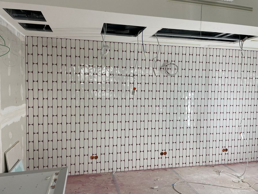 Ovale cremefarbene Wandfliesen mit dunkelroter Fuge